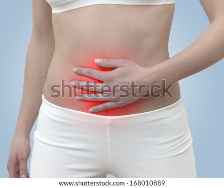 Acute pain in a woman belly. Female holding hand to spot of belly-ache. Concept photo with Color Enhanced blue skin with read spot indicating location of the pain. 