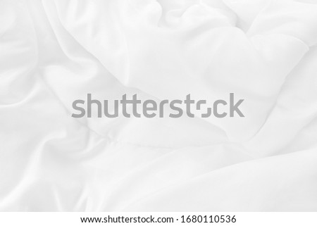 Close up top view of white bedding sheet and wrinkle messy blanket in bedroom after wake up in the morning.