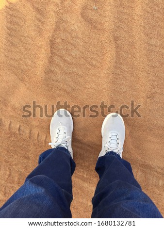 Woman wear jeans and sneaker shoes step on the desert.