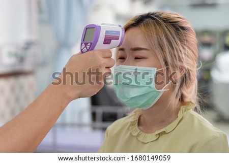 An infrared thermometer Scan Fever And Symptoms of Coronavirus at College , School , Office , Mall , Hospital Royalty-Free Stock Photo #1680149059