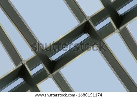 Close-up of steel and glass roof, ceiling or wall. Abstract modern architecture background. Elements of hi-tech office building. Geometric pattern of metal framework. Rectangular grid structure.