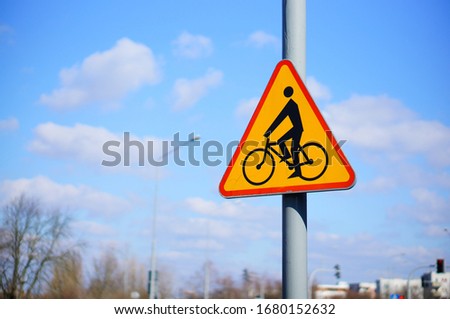 A warning sign on a pole with a blurred background