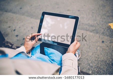 Selective focus woman holding pda device in hands and typing information on blank display of gadget, female fingers touching on blank screen of digital tablet connecting to 4g wireless internet
