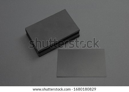 stack and single black blank textured business cards on dark paper background, us size 3.5 x 2 inches, as template for design presentation.