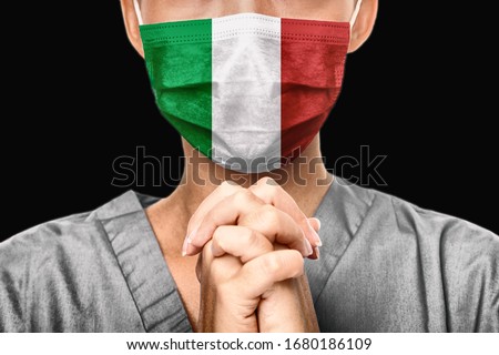 Praying for Italy. Coronavirus pandemic outbreak in Italy. Doctor praying for help. Young woman medical doctor surgeon or nurse portrait.