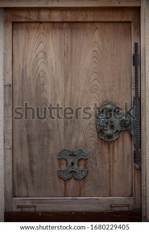 Wooden old-fashioned Japanese door. Weathered metal parts.