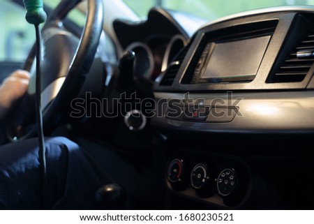 Auto mechanic is sitting in car close up.