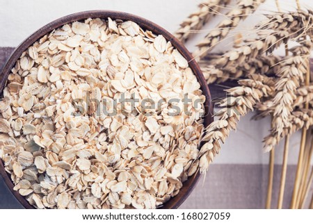 Oat flakes in wooden bowl. Selective focus.