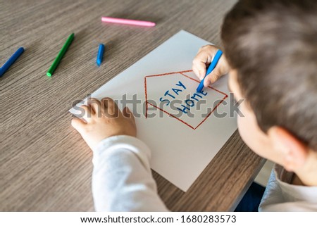 Little kid with Stay Home draw. Coronavirus concept Royalty-Free Stock Photo #1680283573