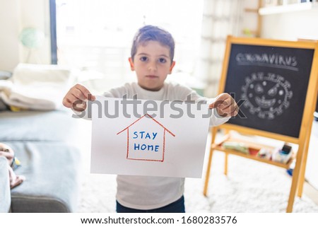 Little kid with Stay Home draw. Coronavirus concept Royalty-Free Stock Photo #1680283576