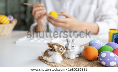 Easter eggs and Decoration on white desk with happy woman painting eggs background. Family preparing for Easter.