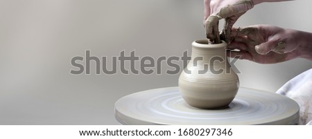 Woman's hands making ceramic cup on potter's wheel Royalty-Free Stock Photo #1680297346