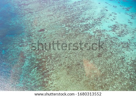 Great Barrier Reef Blue Sea view. Beautiful aqua & turquoise waters, with coral reef patterns in the ocean. View from helicopter, on vacation. Marine life, global warming, protection, island concepts.
