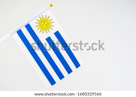 The Uruguayan flag. Official flag of the Eastern Republic of Uruguay. Flag of Uruguay on a white background. A blue-and-white striped banner with the sun at the flagpole. Official symbol of Uruguay.