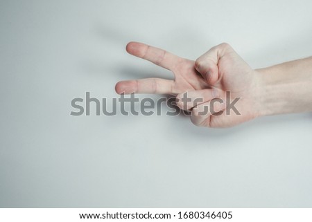 Male hand show two fingers up isolated on a white background. Symbols of the finger of the world are the forces of struggle, the symbol of victory, the letter V in sign language or number two or two.