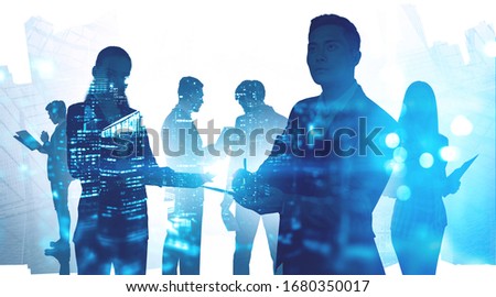 Paperwork and business partnership concept. Silhouettes of diverse business people in city with double exposure of blurry cityscape. Toned image