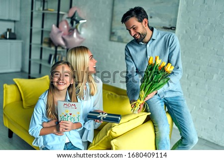Happy mother's day! Father  congratulate mother and gives her a  flowers tulips.