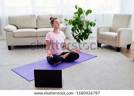 Girl sitting in lotus position and meditating at home interior, copy space. Padmasana. Woman practicing home yoga. Close up hands in meditating gesture. Freedom concept