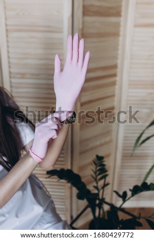 Beauty service master wearing pink medical gloves