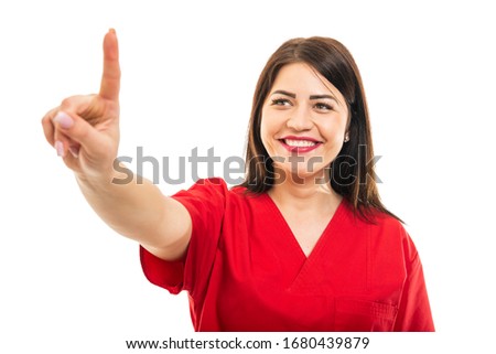 Portrait of beautiful young doctor wearing scrubs using touchscreen isolated on white background