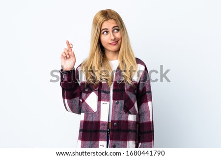 Young Uruguayan blonde woman over isolated white background with fingers crossing and wishing the best