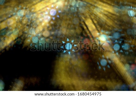 Beautiful bokeh effect eight pointed suns of white and red on a dark golden yellow background with special camera lens filter