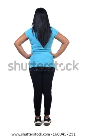 back view of a woman in white background, hands on hip