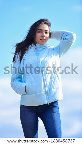 Young and beautiful woman over sky background. above the clouds. looking far away, sense of freedom. future and success. lifestyle concept. trendy girl in casual fall coat. autumn and spring style.