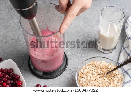 Making homemade smoothie with yoguot, cranberries and oatmeal. Beating a blender for healthy and wholesome nutrition
