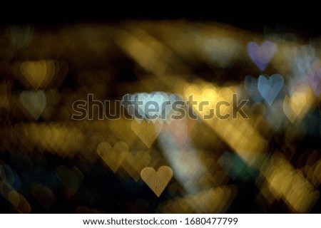 rows of hearts in gold and white on an abstract bokeh effect background with special camera lens filter