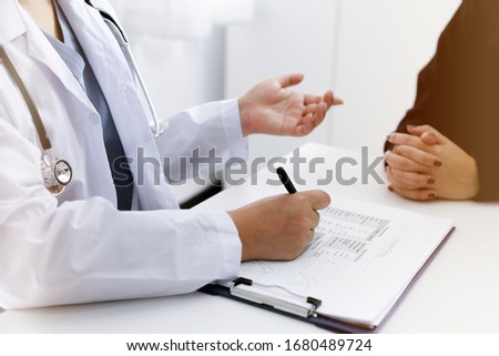 Doctor talking with  patient in doctors office. Royalty-Free Stock Photo #1680489724