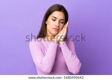 Young caucasian woman over isolated background making sleep gesture in dorable expression