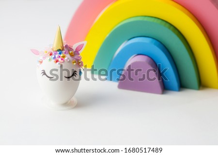 Minimal easter concept. Easter eggs in the shape of a unicorn on a rainbow background. Flat lay. Copy space for text. The portfolio has more Easter pictures.