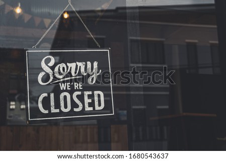 Vintage sorry we are closed sign hanging on a glass door. Royalty-Free Stock Photo #1680543637