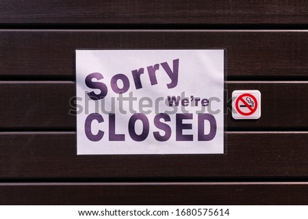 sorry we are closed sign hanging outside a restaurant, store, office or other