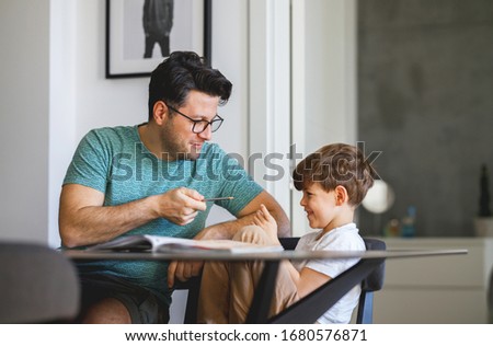 Fathr and son playing while doing homework