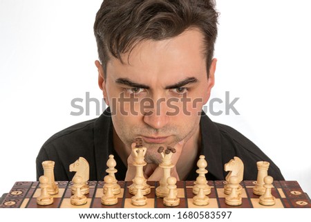 Male chess player contemplating his first move in front of white background. Royalty free stock photo.