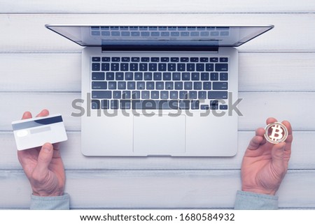 Bitcoin vs bank card online shopping and trading concept. man decides how to pay. Toned picture.