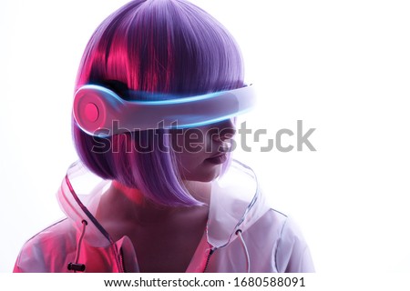 Beautiful woman with purple hair in futuristic costume over white background. Girl in glasses of virtual reality. Augmented reality game, future technology, AI concept. VR. Blue and violet neon light.