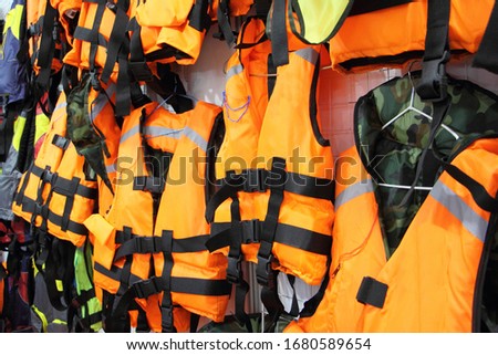 Bright marine life vest signal jackets close up, safety on water tourism activity and watersports Royalty-Free Stock Photo #1680589654