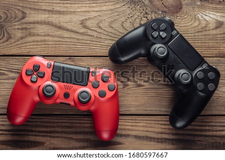 Two Gamepads on wooden table. Gaming, leisure and entertainment concept. Top view