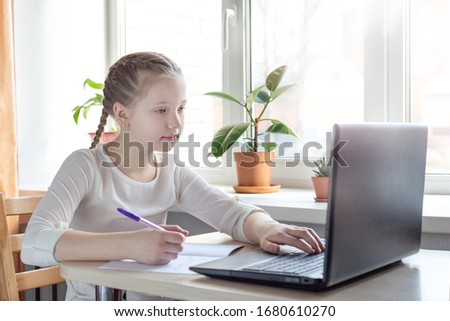 Schoolgirl studying at home using laptop. Home school, online education, home education, quarantine concept - Image
