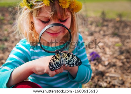 cute girl looking at butterfy, kids learning nature
