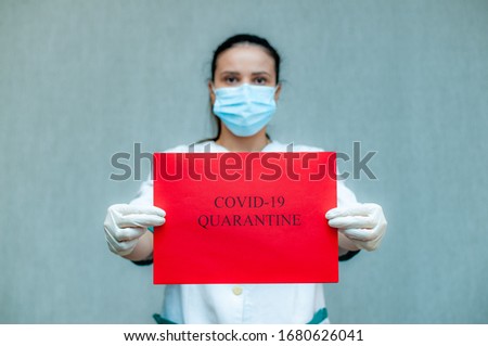 A masked doctor with a red sheet in his hands calling "Quarantine" during the spread of the Kovid-19 virus. The global global problem of the Coronovirus pandemic.
