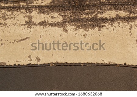 Texture of old used faux leather with cracks. Worn fabric on the couch cushions. Background faux leather material with zipper