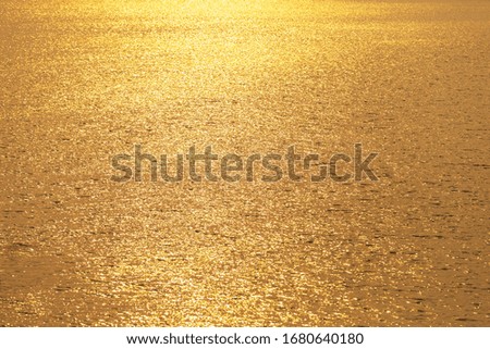 Golden shimmering water background,Golden water reflecting sunset/sunrise