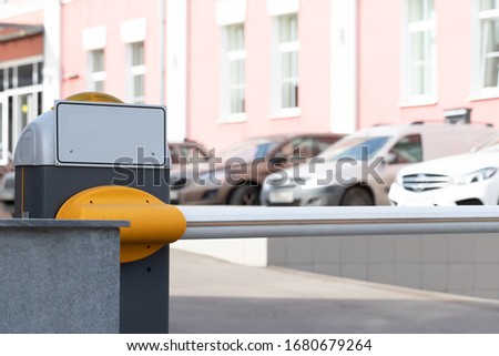 Automatic security barrier boom closed for stop and checking car entering to restricted area , placed at main entrance beside the road , selective focused, blurred background. Security concept or ban