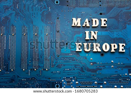 Made in Europe. Inscription on a blue printed circuit board background. Copyspace for design