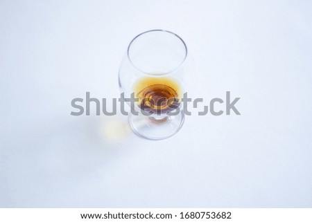 Cognac glass with trace of angel share on white background