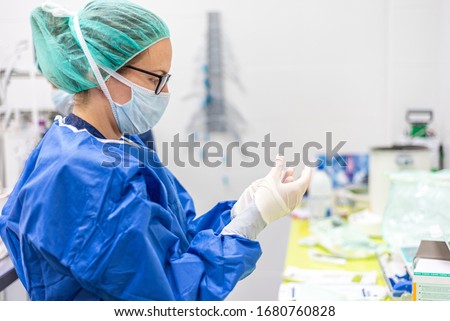 Covid-19. Female nurse puts on protective gloves. Personal protective equipment in the fight against Coronavirus disease . Royalty-Free Stock Photo #1680760828